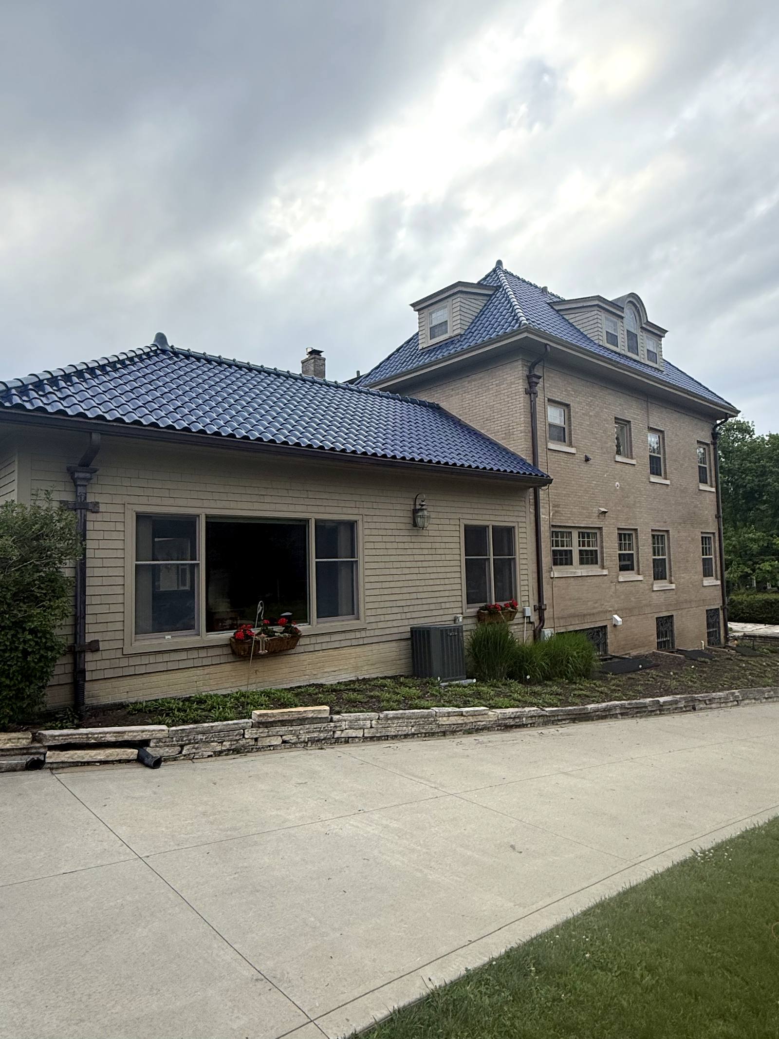 A brick estate home with a navy tile roof in Cedar Rapids after a full interior and exterior window cleaning by Perfect Pane