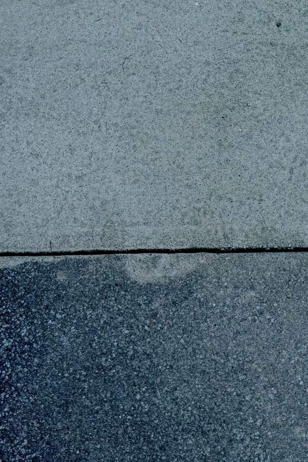 Concrete driveway half cleaned showing the difference pressure washing makes