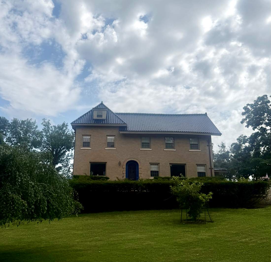 Front elevation of the Cedar Rapids brick estate with navy tile roof