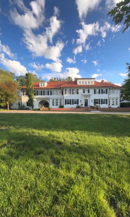 Large white estate home with terracotta tile roof